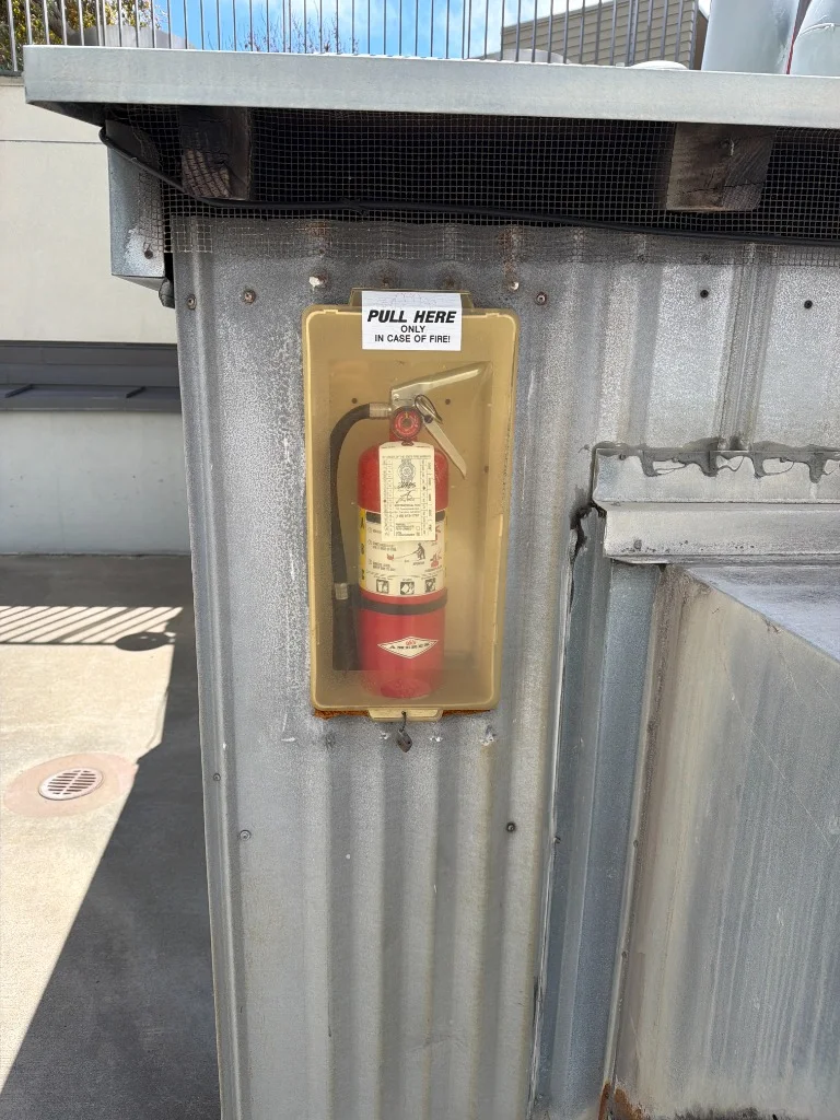 Fire extinguisher securely mounted in an outdoor enclosure at a residential property in San Francisco