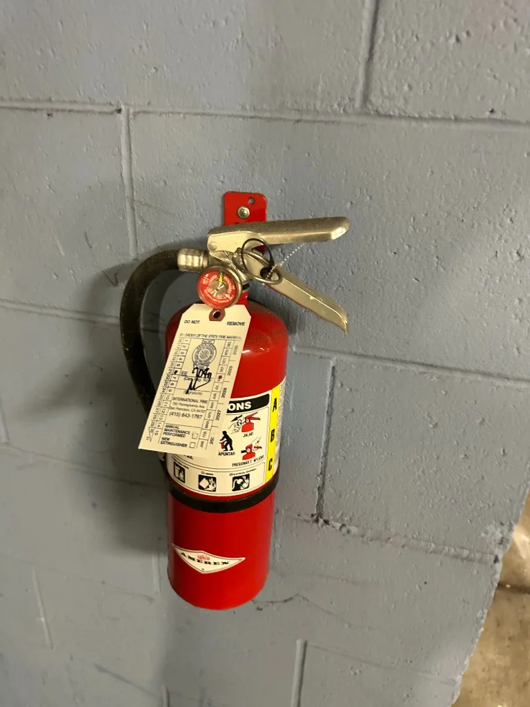 Inspected fire extinguisher on parking garage column at Castro District, San Francisco, CA multi-family residential building in Castro, San Francisco.